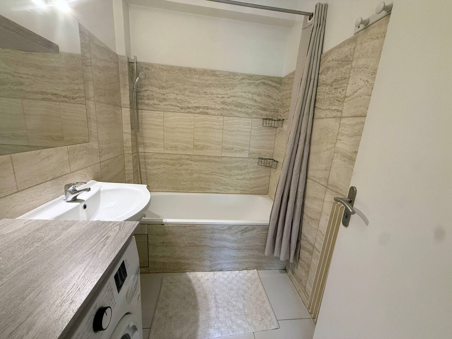 Salle de bain : baignoire avec douche et lave-linge